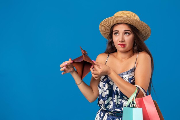 Ritratto di una giovane donna infelice che guarda nel portafoglio nel centro commerciale, ha speso troppo, non abbastanza denaro, ha perso soldi, si è rotto