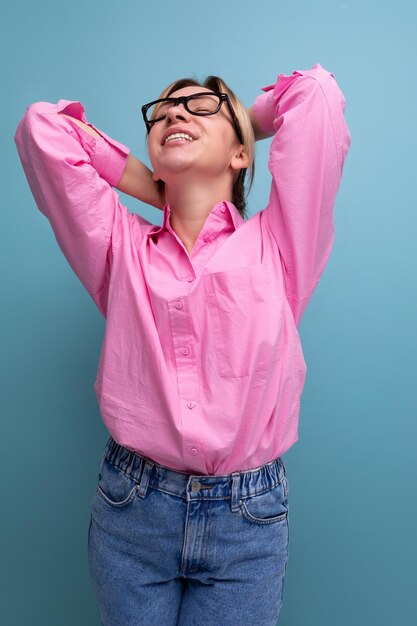 ritratto di una giovane donna leader di carriera bionda di successo in una camicia rosa e occhiali