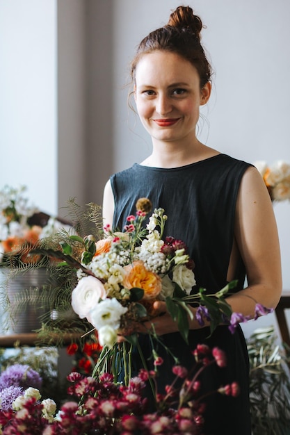 Ritratto di una giovane donna sorridente che tiene un bouquet di fiori