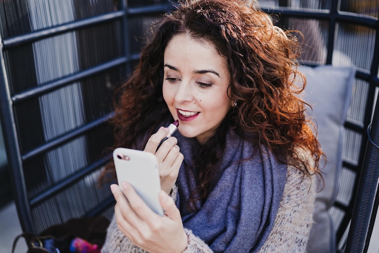Foto ritratto di una giovane donna sorridente che usa un telefono cellulare