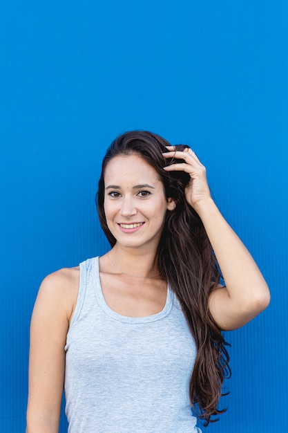 Ritratto di una giovane donna sorridente con parete blu