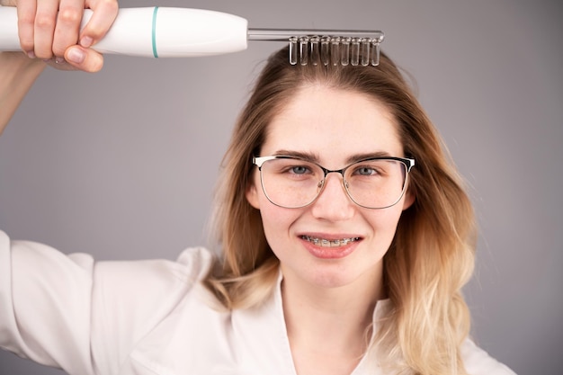 Ritratto di una giovane donna sorridente con una spazzola per i capelli