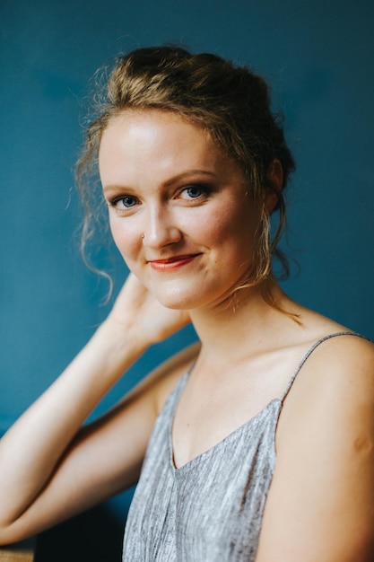 Ritratto di una giovane donna sorridente contro il muro