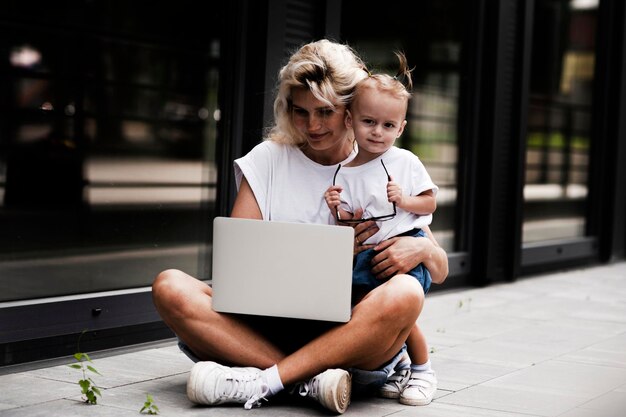 Ritratto di una giovane donna sorridente creativa con un bambino in occhiali da sole. bella ragazza .