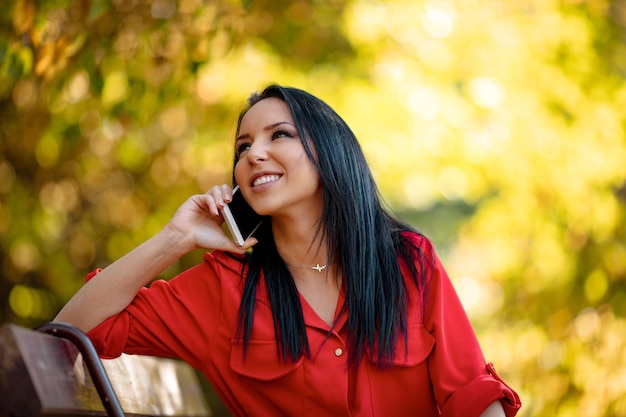 Ritratto di una giovane donna sorridente felice che ascolta ottime notizie sullo smartphone.