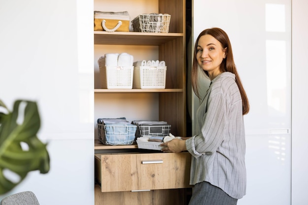 Ritratto di una giovane donna sorridente in piedi in cucina