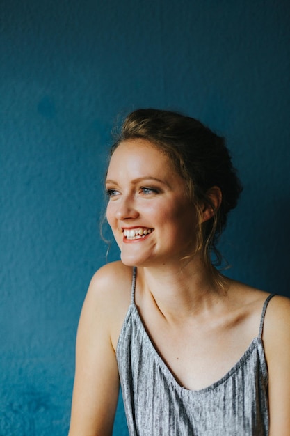 Ritratto di una giovane donna sorridente sullo sfondo blu