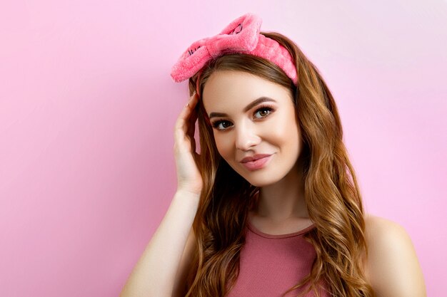 Ritratto di una giovane donna su uno sfondo rosa