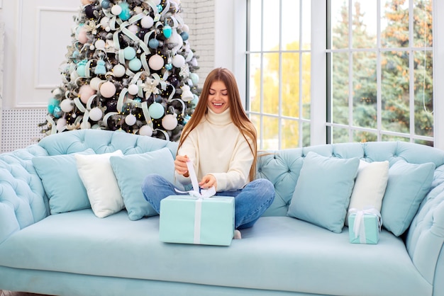 ritratto di una giovane e bella donna a natale sullo sfondo di un albero di natale