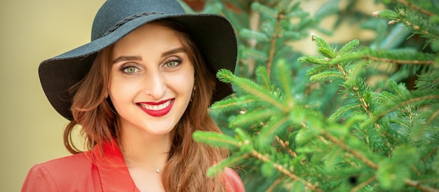 Ritratto di una giovane e bella donna caucasica con albero di Natale sorridente