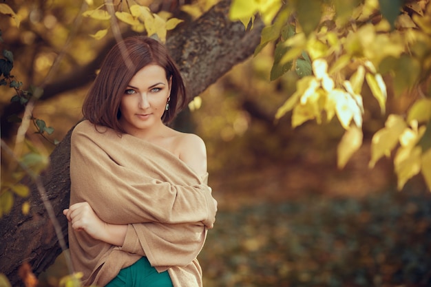 Ritratto di una giovane e bella donna in un parco in autunno. immagini con colori caldi