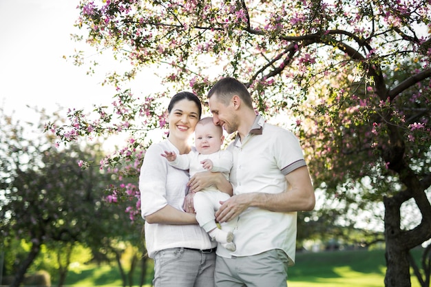 Ritratto di una giovane famiglia con un bambino Felice giovane famiglia che trascorre del tempo all'aperto in una giornata estiva