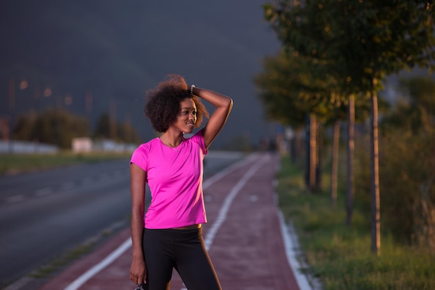 ritratto di una giovane ragazza afroamericana per eseguire una bella serata estiva per le strade della città