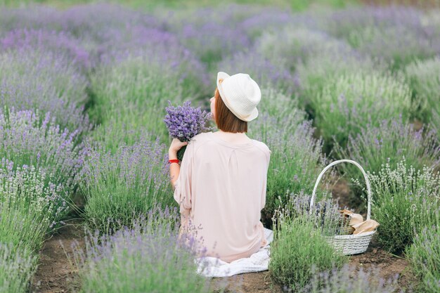 Ritratto di una giovane ragazza carina in un abito rosa in un campo di lavanda