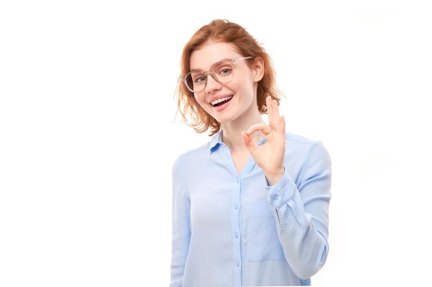 Ritratto di una giovane ragazza che mostra il segno OK con le dita isolate su uno sfondo bianco Concetto accettato per una carriera di successo