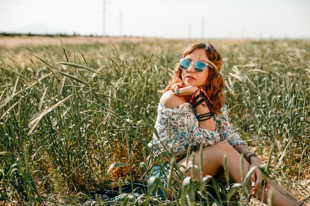 Ritratto di una giovane ragazza hippie su un campo di grano