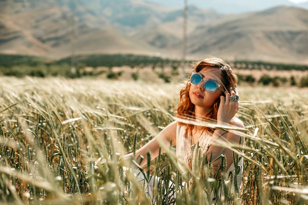 Ritratto di una giovane ragazza in un abito bianco traslucido in stile boho o hippie