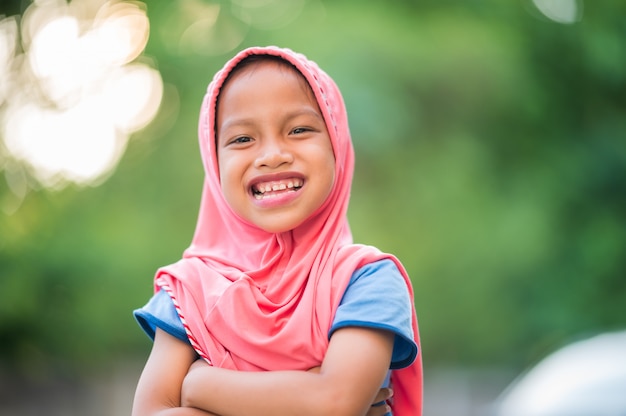 Ritratto di una giovane ragazza musulmana, coperto di panno rosso, sorridente, felice e copia spazio