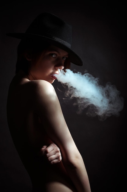 Ritratto di una giovane ragazza nel fumo di sigarette
