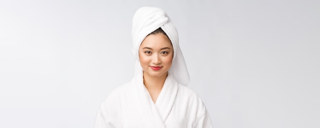 Ritratto di una giovane signora asiatica felice in accappatoioIsolato in uno sfondo bianco