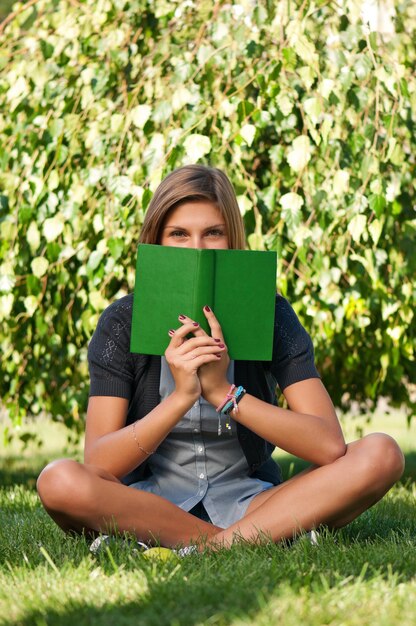 Ritratto di una giovane studentessa con un libro nel campus