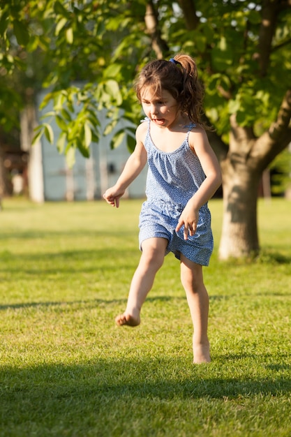 Ritratto di una graziosa bambina che gioca con la palla colorata nel cortile rurale