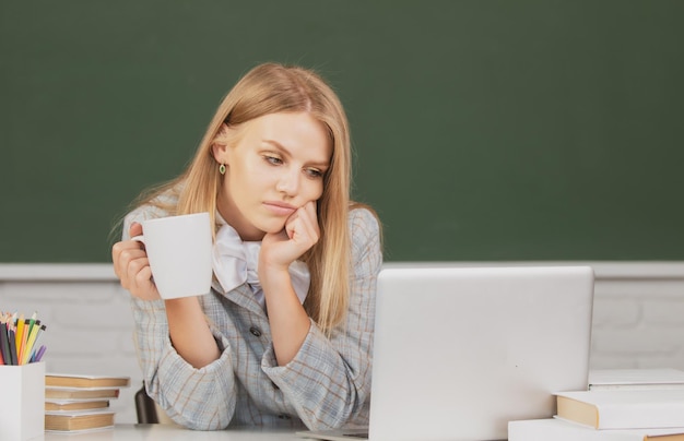 Ritratto di una lezione di studio di una studentessa universitaria che beve caffè o tè a scuola o all'università