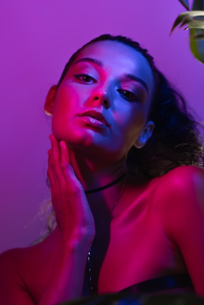 Ritratto di una modella di alta moda in luci blu e viola al neon.