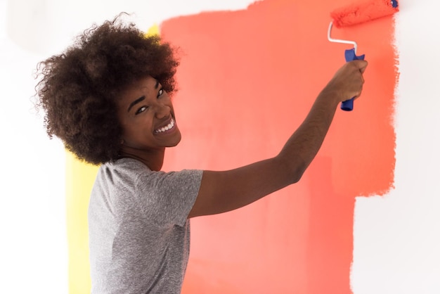 ritratto di una parete di pittura giovane bella donna afroamericana nel suo nuovo appartamento