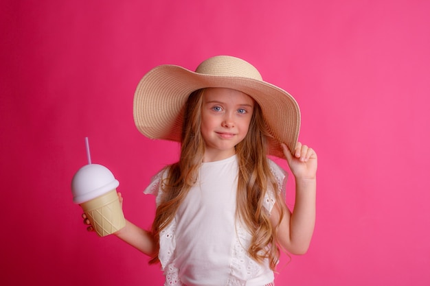 Ritratto di una piccola bionda in un cappello con una lattina di cocktail rinfrescante.