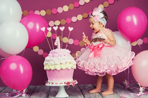 Ritratto di una piccola ragazza di compleanno allegro con la prima torta