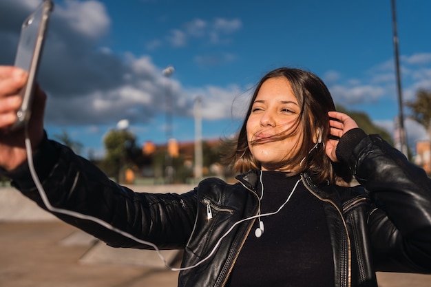 Ritratto di una ragazza allegra che prende un selfie all'aperto.