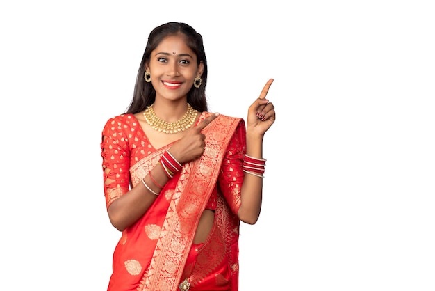 Ritratto di una ragazza allegra di successo che punta e presenta qualcosa con una mano o un dito con una faccia sorridente felice