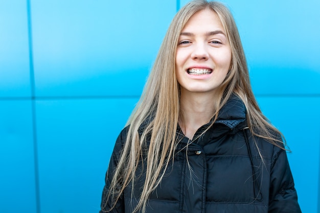 Ritratto di una ragazza allegra e sorridente su sfondo blu, con posto isolato per il testo