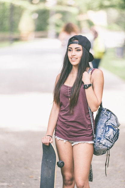 Ritratto di una ragazza bella skater al parco.