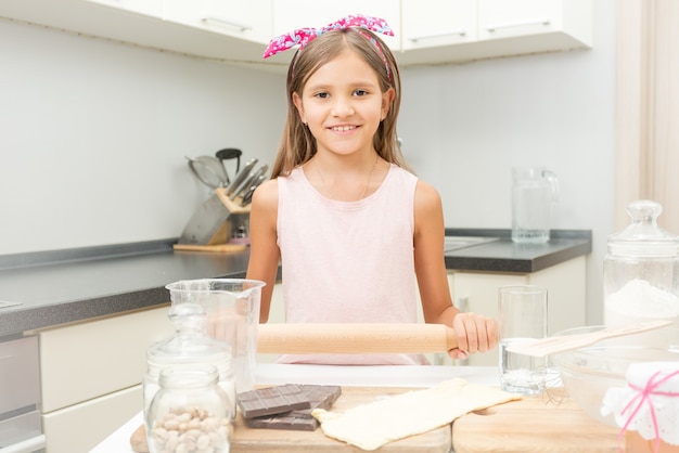 Ritratto di una ragazza carina che impara la cucina in cucina