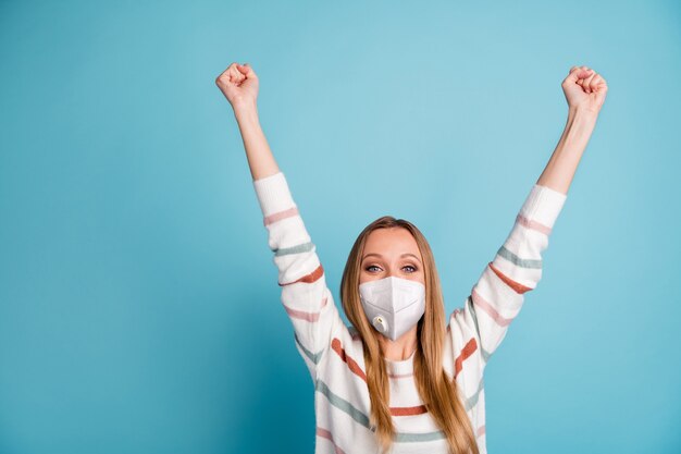 Ritratto di una ragazza che indossa una maschera che si alza con le mani in alto per celebrare il recupero della polmonite influenzale grippe cov