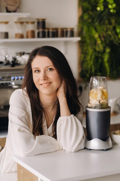 Ritratto di una ragazza che prepara un delizioso cocktail di frutta in cucina Dieta per dimagrire