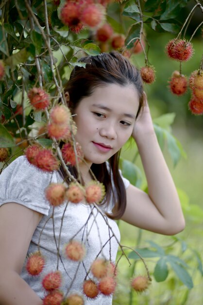 Ritratto di una ragazza con dei fiori sulla pianta