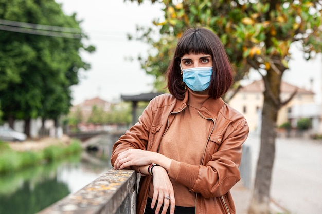 Ritratto di una ragazza con mascherina medica all'aperto durante la quarantena covid in Italia