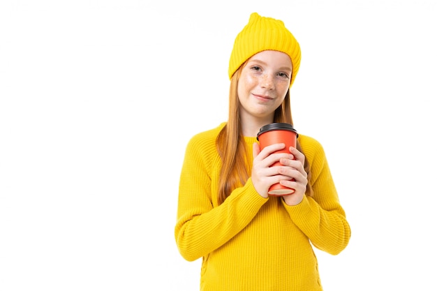 Ritratto di una ragazza con un cappello giallo con un bicchiere di bevanda