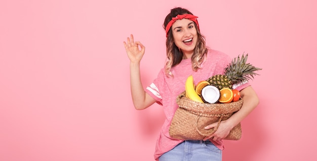 Ritratto di una ragazza con una borsa con frutta isolata