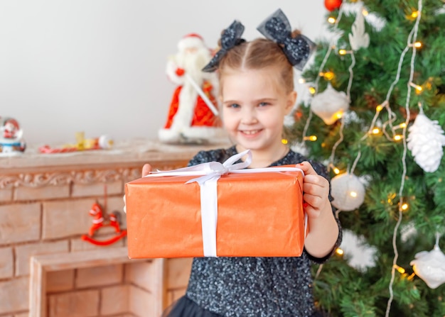 Ritratto di una ragazza felice che tiene un albero di Natale in scatola