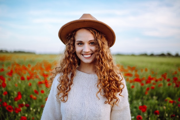 Ritratto di una ragazza felice in un campo di papaveri