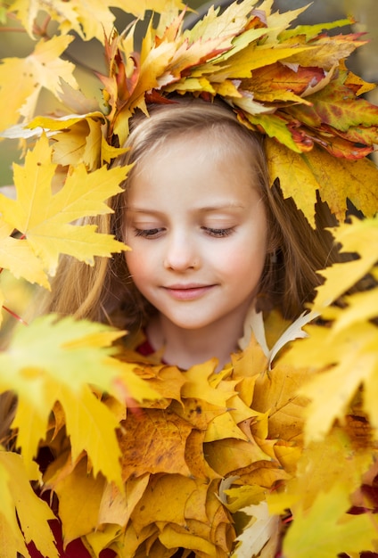 Ritratto di una ragazza in foglie d'autunno