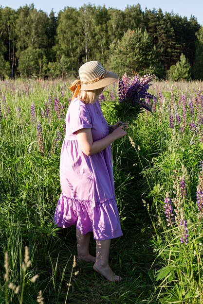 Ritratto di una ragazza in un campo fiorito al sole al tramonto