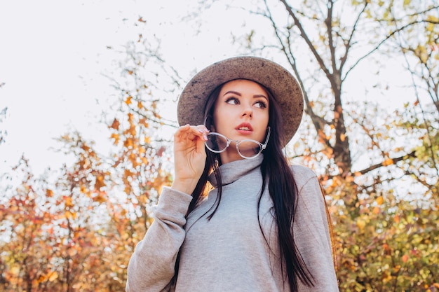 Ritratto di una ragazza in un cappello in un parco in autunno