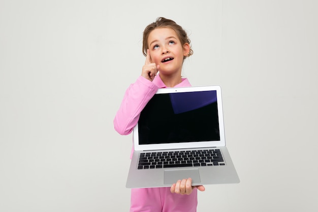 Ritratto di una ragazza in un vestito rosa che mostra uno schermo del computer portatile