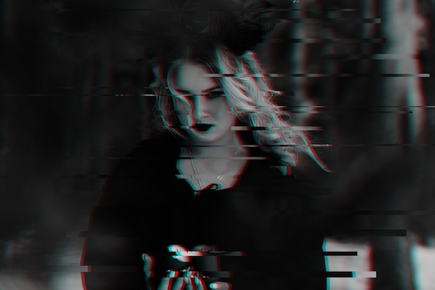 Ritratto di una ragazza nell'immagine di una strega oscura con un'immagine sfocata. Anaglifo in bianco e nero con effetto glitch 3D