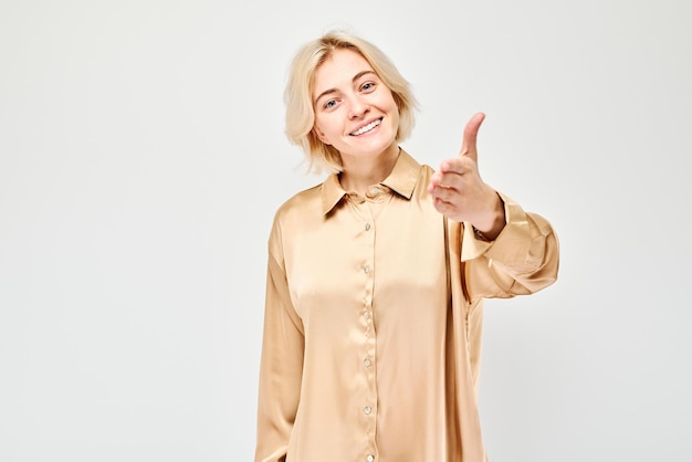 Ritratto di una ragazza sicura di sé che ti sceglie punta il dito alla telecamera isolata su uno sfondo bianco di studio benvenuto gesto unisciti al nostro concetto di squadra